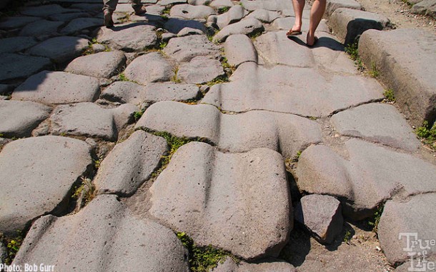 Wagon wheel ruts worn into the street paving stones.