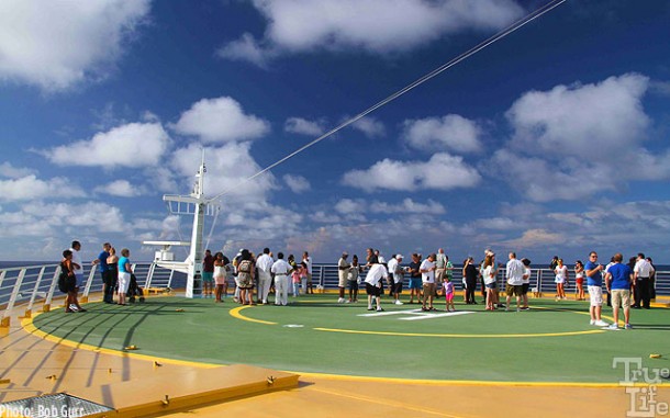 Suites guests gather on the bow heliport for a champagne spillway party.