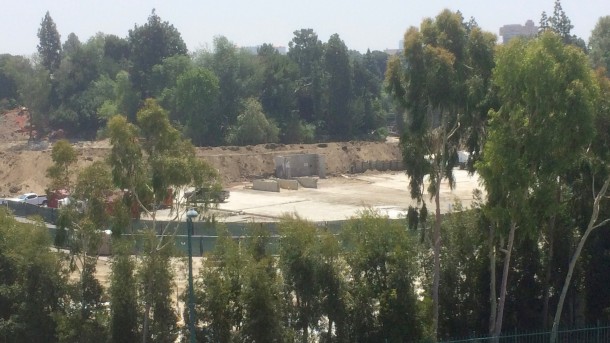 The foliage behind the recently demolished buildings is gone.