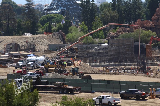 Trucks are pumping cement into forms. 