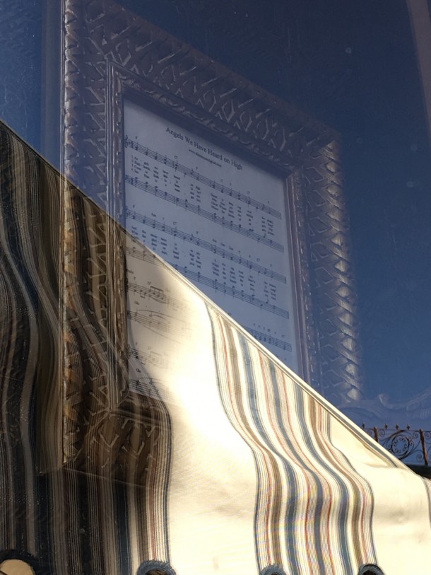It's a little difficult to see because of the reflection, but the sheet music on the wall of the window display at Main Street Music Company is "Angels We Have Heard on High". Oh, and check out the ribbon wrapped around the display itself.