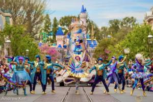 Disneyland Parade Mickey on a Sorcerer Hat float with colorful dancers in front