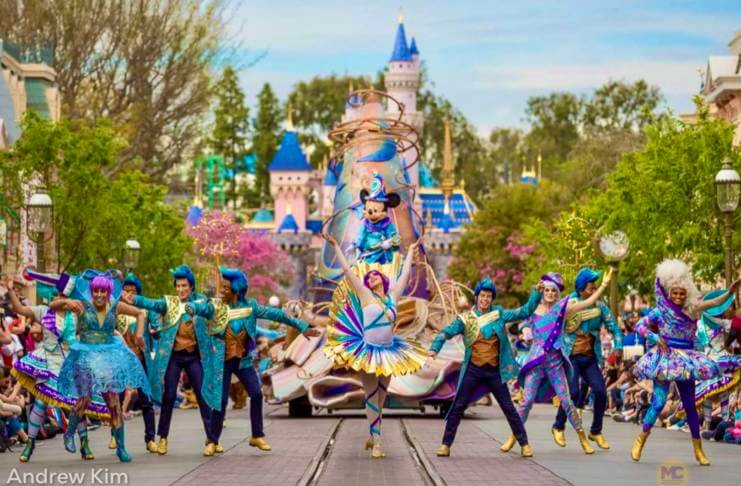 Disneyland Parade Mickey on a Sorcerer Hat float with colorful dancers in front