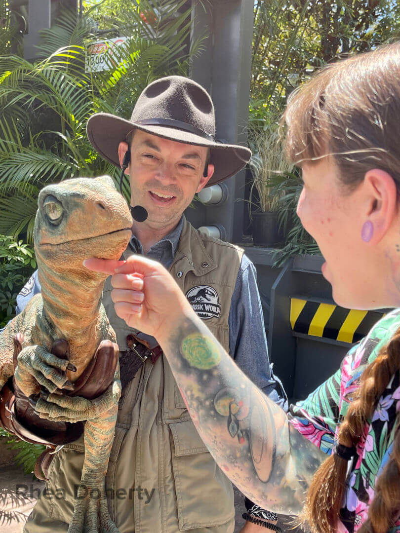 Rhea spending time with a baby raptor at Universal Orlando Resort