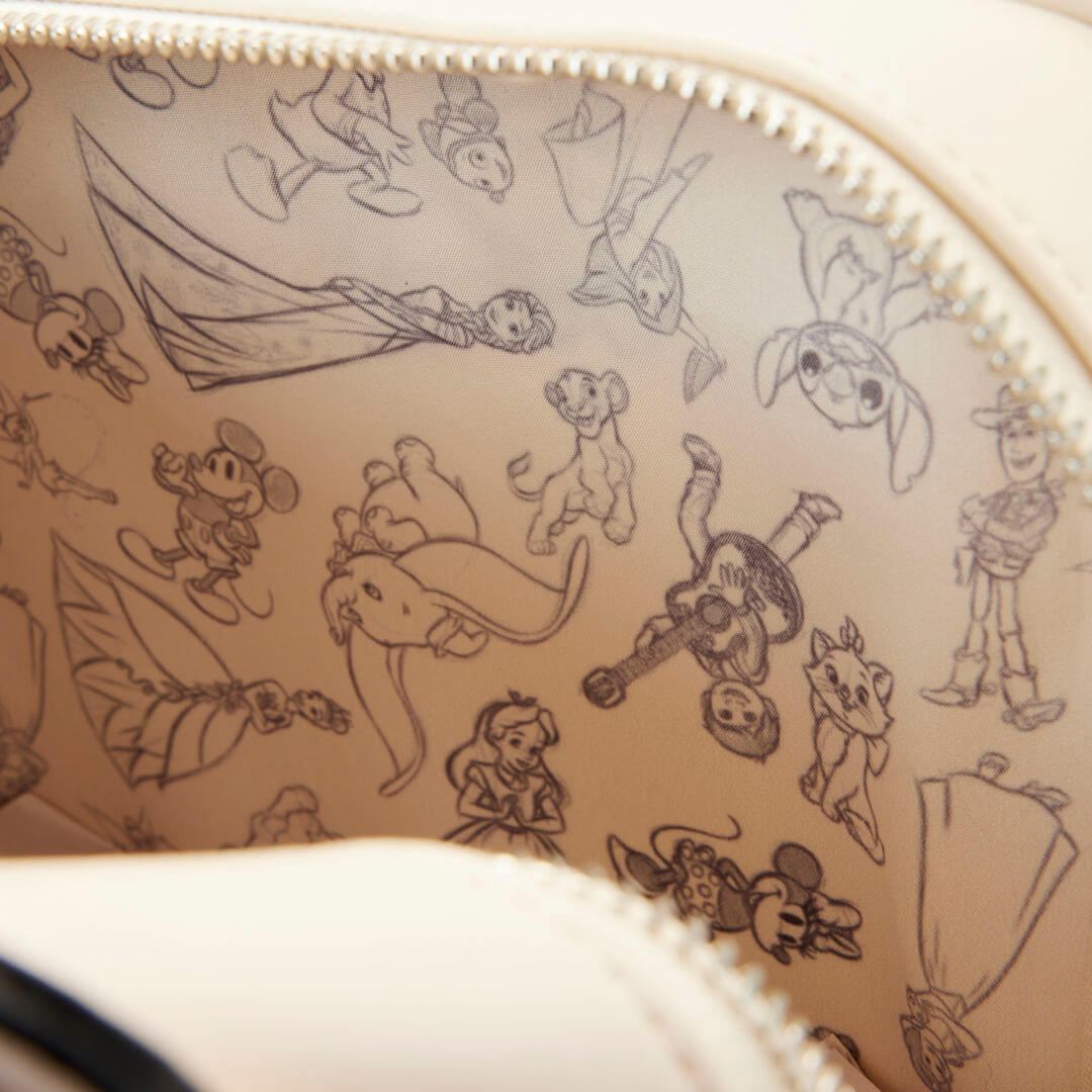 The lining on Loungefly's Disney 100 Sketchbook Collection pin trader backpack is full of characters.