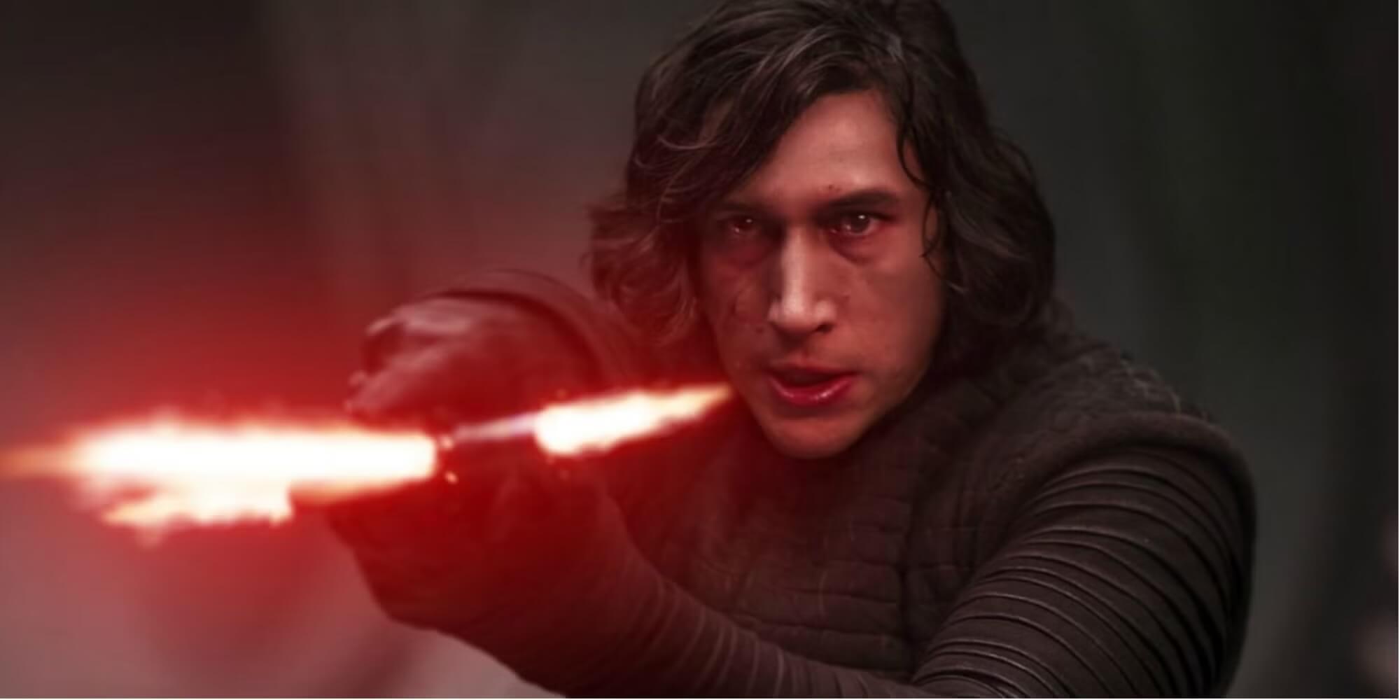 Kylo Ren holding up his red lightsaber and looking angry.