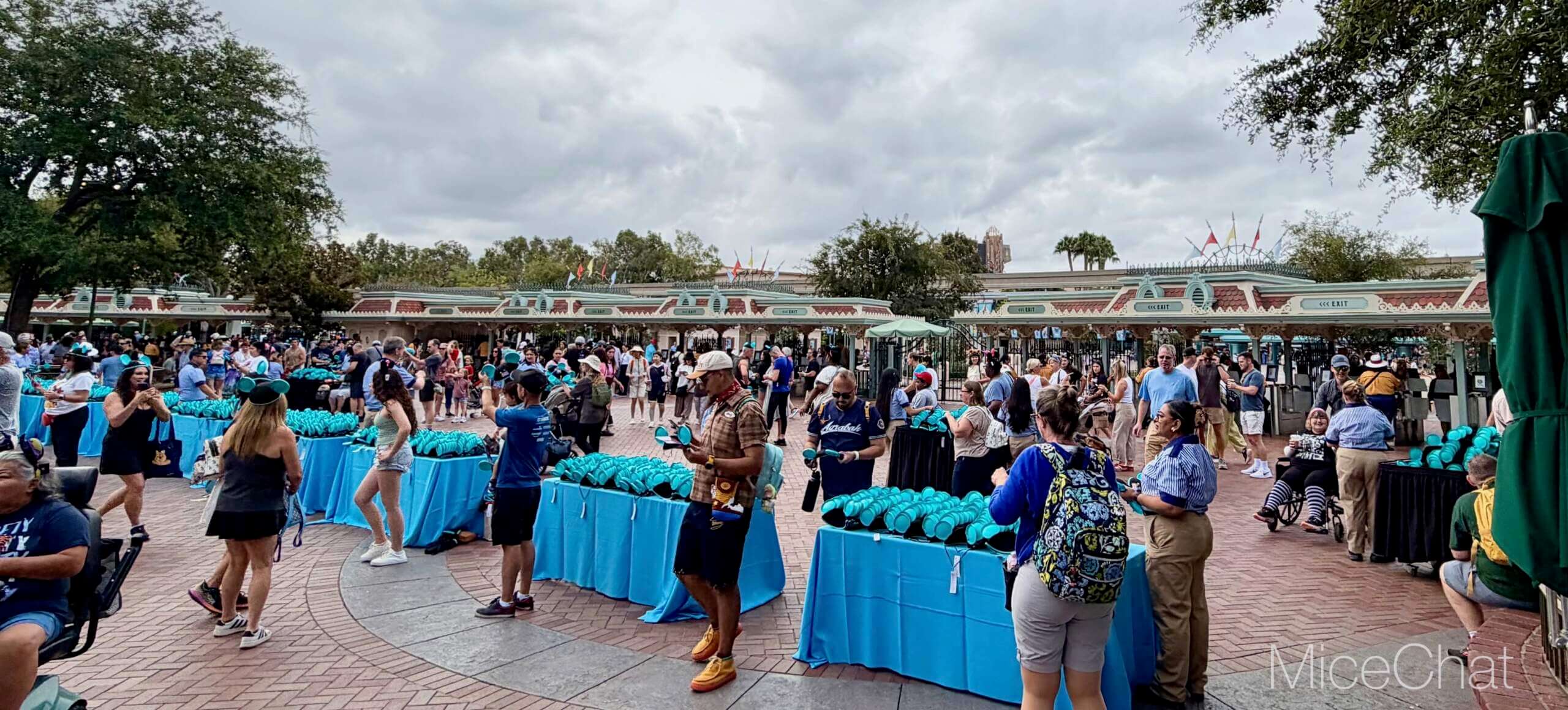 Cast Members hand out complimentary turquoise D23 Mickey ear hats at Disneyland